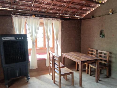 a dining room with a table and a stove at Ishika Homestay in Maheshwar