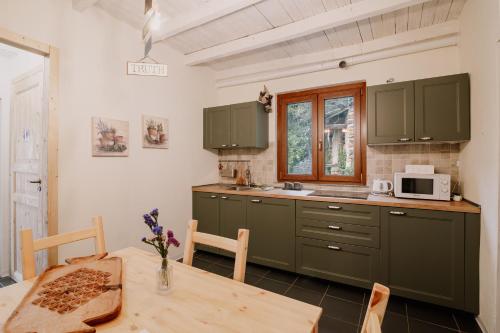 a kitchen with green cabinets and a wooden table at Casa del Bosco in Rubiana