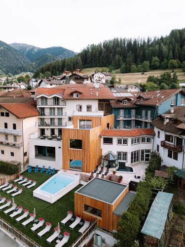 an aerial view of a building with a swimming pool at Cavallino Experience - Alpine Wellness Hotel in Rumo