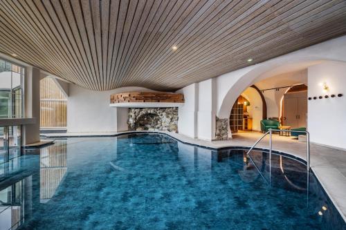a pool in a hotel with a large ceiling at Cavallino Experience - Alpine Wellness Hotel in Rumo