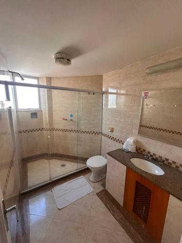 a bathroom with a shower and a toilet and a sink at Hotel Pouso Real in Rio de Janeiro
