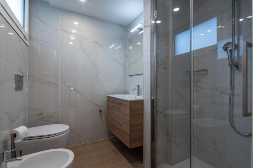 a bathroom with a shower and a toilet and a sink at Hotel Al Sole in Grado