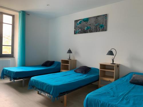 three beds in a room with blue sheets at Gite Des Sibourgs - Piscine & Clim in Bourdeaux