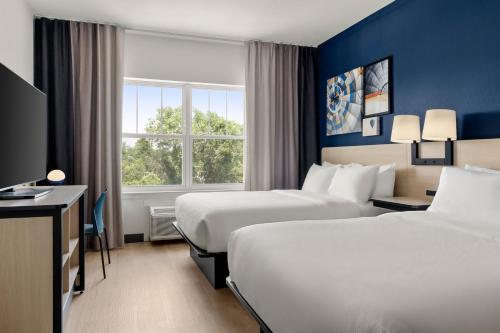 a hotel room with two beds and a window at City Express By Marriott Gettysburg in Gettysburg
