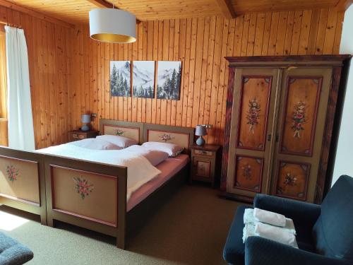 a bedroom with a bed and a wooden wall at Ciasa Lovara in Lovara