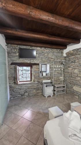 a living room with a stone wall and a bed at Residenza Villa Paradiso in Villadossola