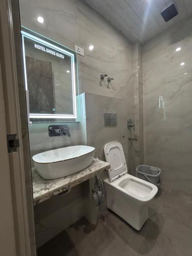 a bathroom with a sink and a toilet at Grand Tree Hotel Shree Guru in New Delhi