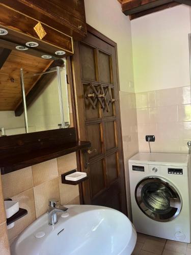 a bathroom with a washing machine and a sink at la Mansarda dello Zio in Ceppo Morelli