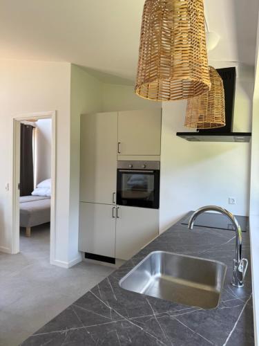 a kitchen with a sink and a microwave at Kysthusene in Gilleleje