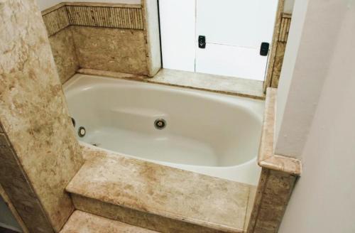 a bath tub in the corner of a bathroom at Maison Collection Classic in Porto Velho