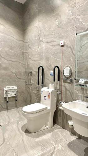 a bathroom with a toilet and a sink at اجنحة الفخامة للشقق الفندقية in Taif