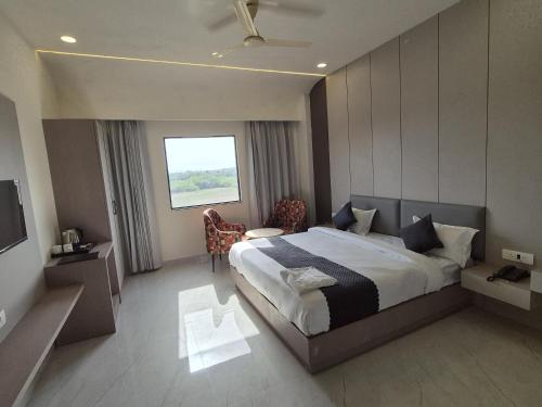 a bedroom with a large bed and a window at Hotel Arena in Nasīrābād