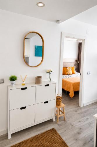 a bedroom with a white dresser and a mirror at Festasol - Apartament Estartit in Torroella de Montgrí