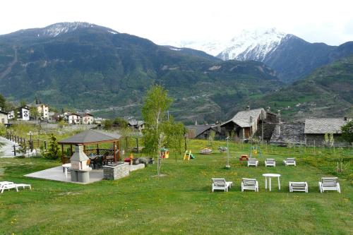 a park with chairs and a gazebo and mountains at Affittacamere Verger Plein Soleil in Saint-Pierre