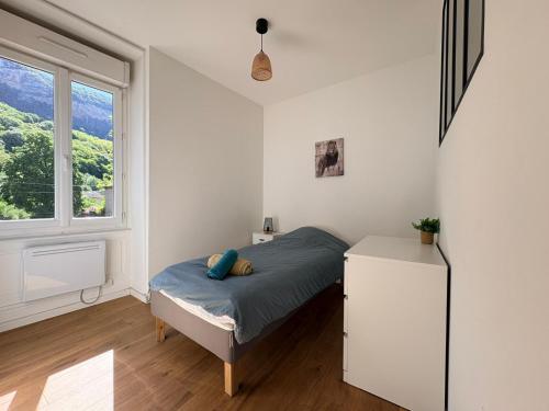 a bedroom with a bed and a window at Appartement La Jungle in Villebois