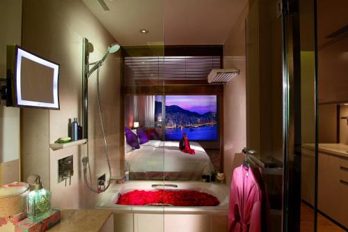 a bathroom with a shower and a tub with a bed at The HarbourView Place @ the ICC megalopolis in Hong Kong
