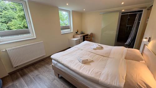 a bedroom with a large white bed and a window at Haus Mariengrund in Münster