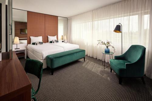 a hotel room with a bed and a chair at Van der Valk Zaltbommel-A2 in Zaltbommel
