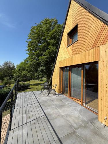 a house with a deck with a bench on it at Chalet Galla in Horní Blatná