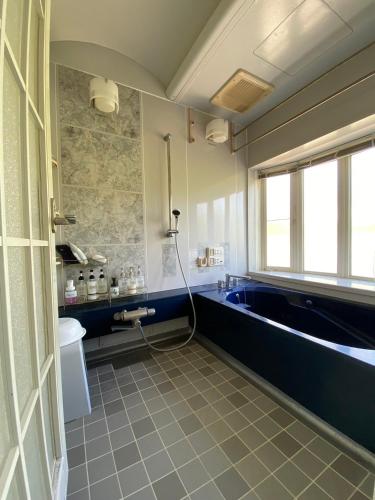a bathroom with a sink and a bath tub at Beach House Bellissima ! in Yomitan