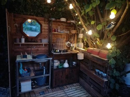 a kitchen with a sink and a mirror at THOUARS Rivière LODGE KAËLI in Maulais