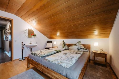 a bedroom with a large bed with a wooden ceiling at Haus Heidi in Freyung