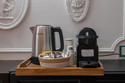 a coffeemaker sitting on top of a wooden tray with a tea kettle at Hotel Moscatello in Rome
