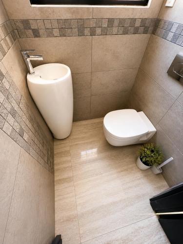a bathroom with a white toilet and a sink at Villa 280 m2 in Sète