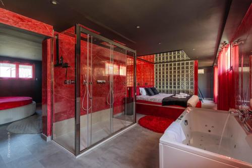 a bathroom with a shower and a tub and a bed at L'Interdit, Confort et Sensualité in La Ferté-Gaucher