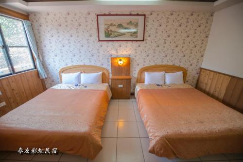 two beds in a hotel room with twoermottermott at Rainbow SpringYU B&B in Nanzhuang
