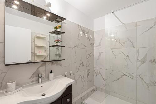 a white bathroom with a sink and a shower at Suite Sainte-Hélène FSHH in Nice