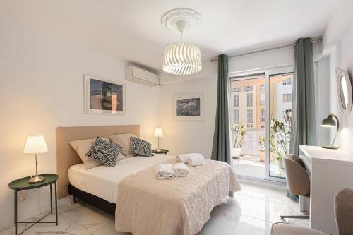 a bedroom with a bed and a large window at Suite Sainte-Hélène FSHH in Nice
