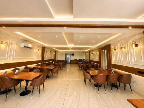 a dining room with wooden tables and chairs at The hotel golden crown in Baddi