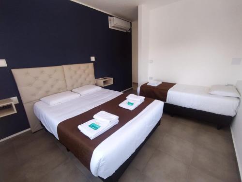 a hotel room with two beds with towels on them at Hotel Astoria in Villa Carlos Paz