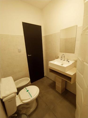 a bathroom with a toilet and a sink and a mirror at Hotel Astoria in Villa Carlos Paz