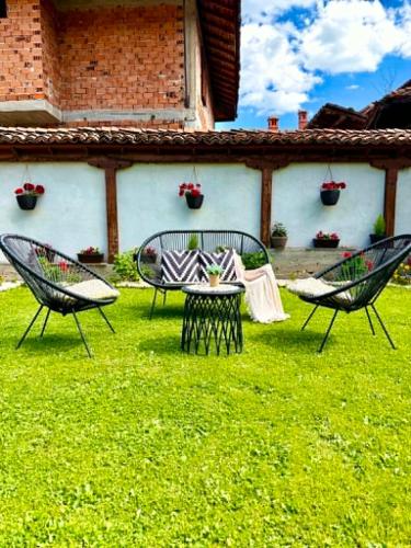 two chairs and a table in the grass at Арбория in Koprivshtitsa