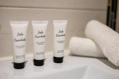 a group of four tubes of sunscreen sitting on a bathroom counter at Sundale House in Lurgan