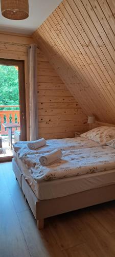 a bedroom with a large bed in a wooden ceiling at Dom na wyłączność U Eskulapa in Lutowiska