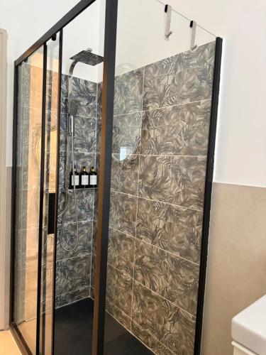 a shower with a glass door in a bathroom at AuraHouse in Mignanego