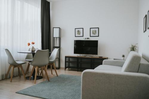 a living room with a couch and a table with a tv at Hotel Central Vlašić in Vlasic