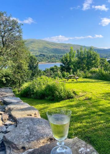 a glass of wine sitting on top of a rock wall at Cuil Steading in Cairndow