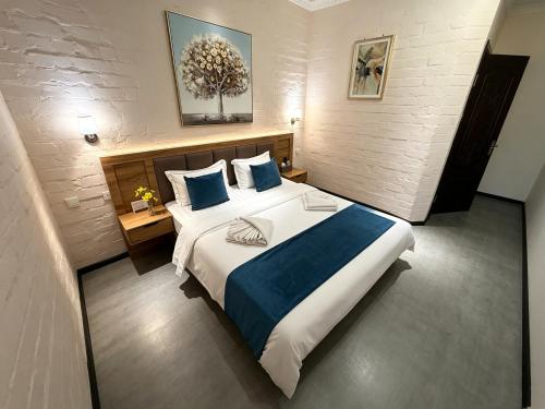 a bedroom with a large bed with blue pillows at AERON hotel in Yakkasaray