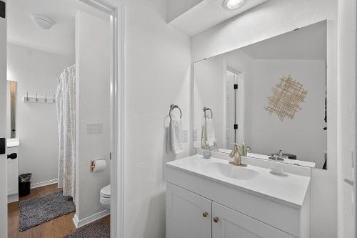 a white bathroom with a sink and a mirror at Birdies & Bikes at Fairway 45 in Bella Vista
