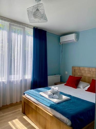 ein blaues Schlafzimmer mit einem Bett und einem Tablett mit Handtüchern. in der Unterkunft жули in Gonio
