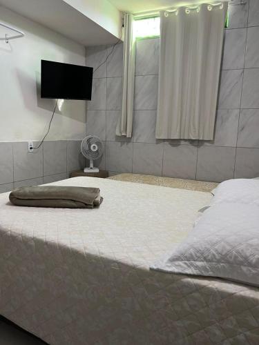 a bedroom with a large bed with a flat screen tv at Jardim Tropical in Bayeux