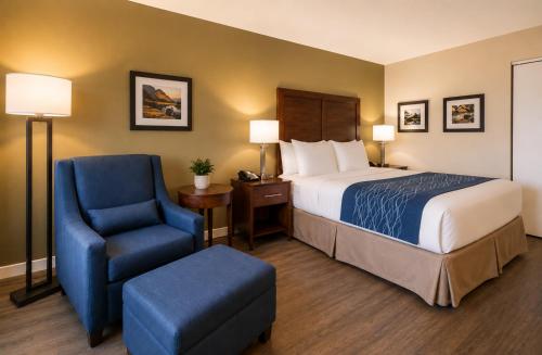 a hotel room with a bed and a chair at Comfort Inn in Saint-Georges