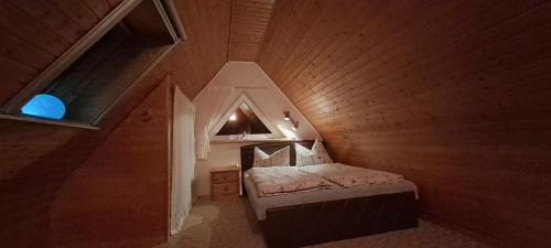 a small attic bedroom with a bed and a window at Haus Haase in Prenzlau