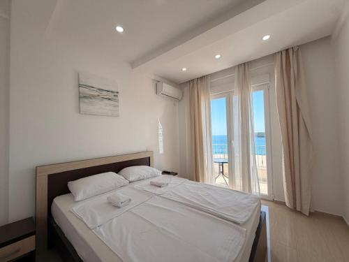 a bedroom with a large bed and a large window at Beachfront Hotel Palma - Jaz in Budva