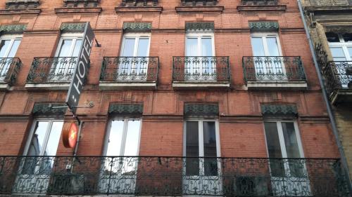a red brick building with windows and balconies at Hotel Boreal in Toulouse