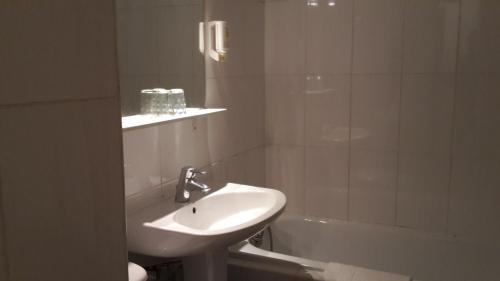 a bathroom with a sink and a bath tub and a sink at Hotel Boreal in Toulouse
